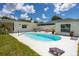 Gorgeous backyard with a kidney-shaped pool, white patio, lawn, and exterior of a white house beneath a partly cloudy sky at 5314 13Th S Ave, Gulfport, FL 33707