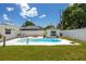 Beautiful backyard oasis with a kidney-shaped pool, manicured lawn, white patio, and home exterior on a sunny day at 5314 13Th S Ave, Gulfport, FL 33707