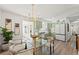 Bright dining area with a glass table, modern chandelier, and adjacent kitchen with green cabinets and stainless steel appliances at 5314 13Th S Ave, Gulfport, FL 33707
