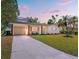 Charming single-story home featuring a lush lawn, attached garage, and a welcoming turquoise-colored front door at 5314 13Th S Ave, Gulfport, FL 33707