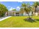 Inviting home featuring a lush green lawn, palm trees, and a cheerful blue front door at 5314 13Th S Ave, Gulfport, FL 33707