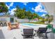 Inviting backyard oasis featuring a kidney-shaped pool, outdoor seating, and lush landscaping under a bright, partly cloudy sky at 5314 13Th S Ave, Gulfport, FL 33707