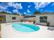 Relaxing backyard showcases a pristine kidney-shaped pool surrounded by a white patio and charming white house exterior at 5314 13Th S Ave, Gulfport, FL 33707