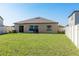 View of the house exterior and large, fenced backyard showcasing a well-maintained lawn at 5412 Olano St, Palmetto, FL 34221