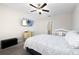 Comfortable bedroom featuring soft gray carpet, ceiling fan, TV, and a gray and white coverlet at 5412 Olano St, Palmetto, FL 34221