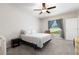 Comfortable bedroom with soft gray carpet, ceiling fan, a gray and white coverlet, and a window view at 5412 Olano St, Palmetto, FL 34221