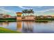 Community entrance with elegant signage, lush landscaping, and a serene lake view at 5412 Olano St, Palmetto, FL 34221
