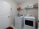 Bright laundry room with washer, dryer, white cabinets, and tile floor at 5412 Olano St, Palmetto, FL 34221