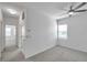 Bright bedroom with white walls, ceiling fan, and carpeted floor, featuring a window with blinds at 5728 Skytop Dr, Lithia, FL 33547