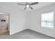 Cozy carpeted bedroom with window, ceiling fan, and view to the bathroom, creating a relaxing atmosphere at 5728 Skytop Dr, Lithia, FL 33547