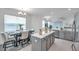 Bright open-concept kitchen featuring white countertops, grey cabinets, stainless appliances, and an adjacent dining area at 5728 Skytop Dr, Lithia, FL 33547