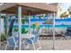 Outdoor lounge area with a table and chairs adjacent to a mural of a tropical beach at 5840 30Th S Ave # 305, Gulfport, FL 33707