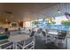 Outdoor covered patio with multiple tables and chairs overlooking a pool with tropical landscaping at 5840 30Th S Ave # 305, Gulfport, FL 33707