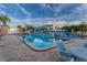 Community pool with clear blue water and patio furniture, with tropical foliage and palm trees around it at 5840 30Th S Ave # 305, Gulfport, FL 33707