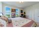 Bedroom with a floral comforter, desk, computer, and sunny windows at 628 Cleveland St # 907, Clearwater, FL 33755