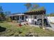 Outdoor living space with patio, pergola, and seating, ideal for relaxation and entertainment in the backyard at 7716 W Hiawatha St, Tampa, FL 33615