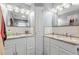 Double vanity bathroom with granite counters, stylish mirrors and updated fixtures at 8329 Broken Willow Ln, Port Richey, FL 34668