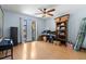 Bedroom with a ceiling fan, hardwood floors, and two large windows at 8329 Broken Willow Ln, Port Richey, FL 34668