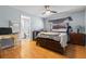 Bedroom with wood floors, ceiling fan, and bathroom access at 8329 Broken Willow Ln, Port Richey, FL 34668