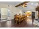 Dining room featuring wood floors, stone fireplace, wood beam ceiling, and access to the kitchen at 8329 Broken Willow Ln, Port Richey, FL 34668