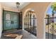 Covered entryway with tiled floor, ornate double doors, and wrought iron gate at 8329 Broken Willow Ln, Port Richey, FL 34668