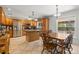 Open kitchen with wood cabinets, island, stainless steel appliances and eat-in dining area at 8329 Broken Willow Ln, Port Richey, FL 34668