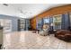 Bright living room features tile floors, wood accent wall, neutral paint and many windows at 8329 Broken Willow Ln, Port Richey, FL 34668