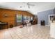 Large living room offers tile floors, wood accent wall, neutral paint and many windows at 8329 Broken Willow Ln, Port Richey, FL 34668