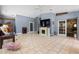 Open living room features tile floors, fireplace, high ceilings, French doors, and lots of natural light at 8329 Broken Willow Ln, Port Richey, FL 34668