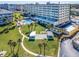 Aerial view of the property showcasing the pool, lawn, shuffleboard courts, and landscaping at 100 Bluff View Dr # 317A, Belleair Bluffs, FL 33770