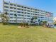 Stunning multi-story building with a well-manicured lawn, palm trees, and an American flag waving proudly at 100 Bluff View Dr # 317A, Belleair Bluffs, FL 33770