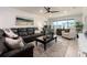 Bright living room with a large leather sofa, accent chair, and a view of the outdoors at 100 Bluff View Dr # 317A, Belleair Bluffs, FL 33770