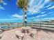 Scenic outdoor seating area features a table, benches, and palm tree with beautiful water views at 100 Bluff View Dr # 317A, Belleair Bluffs, FL 33770
