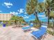 Relaxing pool deck with lounge chairs and beautiful views of palm trees and the water at 100 Bluff View Dr # 317A, Belleair Bluffs, FL 33770