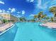 Inviting community pool with blue lounge chairs for relaxation and a beautiful sunny sky backdrop at 100 Bluff View Dr # 317A, Belleair Bluffs, FL 33770