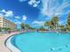 Inviting community pool with blue lounge chairs for relaxation and a beautiful sunny sky backdrop at 100 Bluff View Dr # 317A, Belleair Bluffs, FL 33770