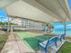 Covered shuffleboard court and seating near the building and waterfront at 100 Bluff View Dr # 317A, Belleair Bluffs, FL 33770