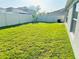 A spacious backyard features lush green grass and a white privacy fence at 10105 Paradise Fish Dr, Riverview, FL 33578
