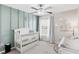 Charming Bedroom featuring a white crib, changing table, and modern decor at 10105 Paradise Fish Dr, Riverview, FL 33578