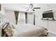 Light-filled main bedroom showcases a ceiling fan, bedside table, and window with natural light at 10105 Paradise Fish Dr, Riverview, FL 33578
