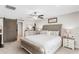 Cozy main bedroom features a tufted headboard, ceiling fan, and sliding barn door to the ensuite bathroom at 10105 Paradise Fish Dr, Riverview, FL 33578
