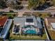 Aerial view of a home with a pool, solar panels, well-maintained landscaping, and fenced backyard at 1017 Jamaica Way, Tarpon Springs, FL 34689