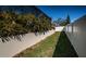 Lush backyard featuring a well-maintained fence, mature plants along the block wall and a small grassy area at 1017 Jamaica Way, Tarpon Springs, FL 34689