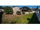 View of the backyard featuring a shed, screened enclosure, and green grass against a backdrop of a white vinyl fence at 1017 Jamaica Way, Tarpon Springs, FL 34689