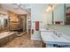Bathroom with double sinks, glass shower, soaking tub, and neutral tile at 1017 Jamaica Way, Tarpon Springs, FL 34689