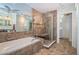 Bathroom featuring large tub, glass shower, and double sinks at 1017 Jamaica Way, Tarpon Springs, FL 34689