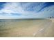 Sandy beach at Tarpon Springs with clear water and gentle waves under a partly cloudy sky at 1017 Jamaica Way, Tarpon Springs, FL 34689