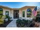Charming home with meticulous landscaping, featuring an American flag, and a welcoming front entrance at 1017 Jamaica Way, Tarpon Springs, FL 34689