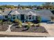 Attractive home features a well-kept lawn, lush plantings, neutral color palette, and a welcoming entrance at 1017 Jamaica Way, Tarpon Springs, FL 34689