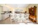 Sunny kitchen with a large island, granite counters, stainless steel appliances, and white cabinetry at 1017 Jamaica Way, Tarpon Springs, FL 34689